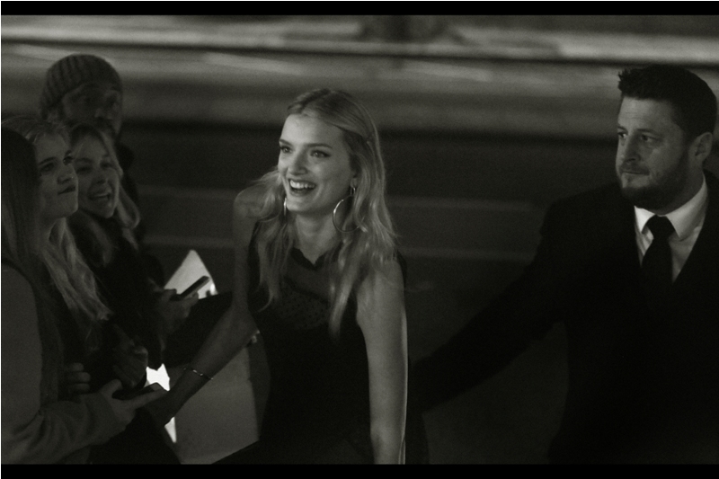 I don't know who this is, but the security guard is helping her find her footing on unsteady pavement... or injecting her with antibiotics for exposure to London's ferocious autograph dealers.