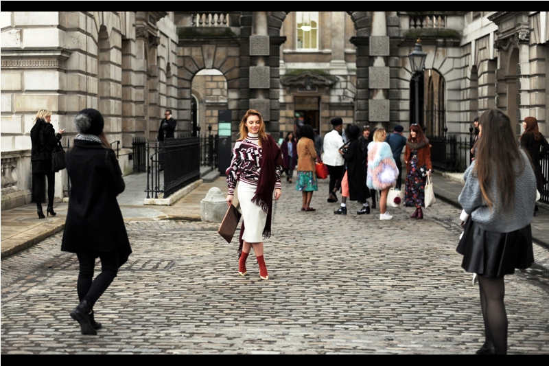Due to the lack of knowledge in all things fashion and fashion-related that I've carefully cultivated and made no moves whatsoever to address over the course of whole decades, I can't say for certain based on this photo what exactly is "IN" this year. Is it scarves? red socks with white shoes? carrying hanging rectangles? being watched by two people dressed in monochrome? standing with your legs weirdly crossed? I just don't know...