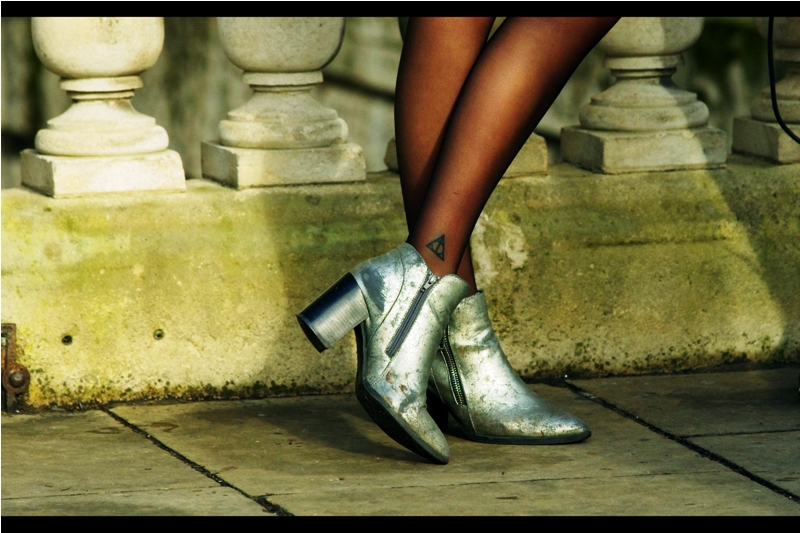 Is it cool that I recognise this as the sign of The Deathly Hallows, or uncool that I'm looking at a girl's legs this closely without introducing myself?