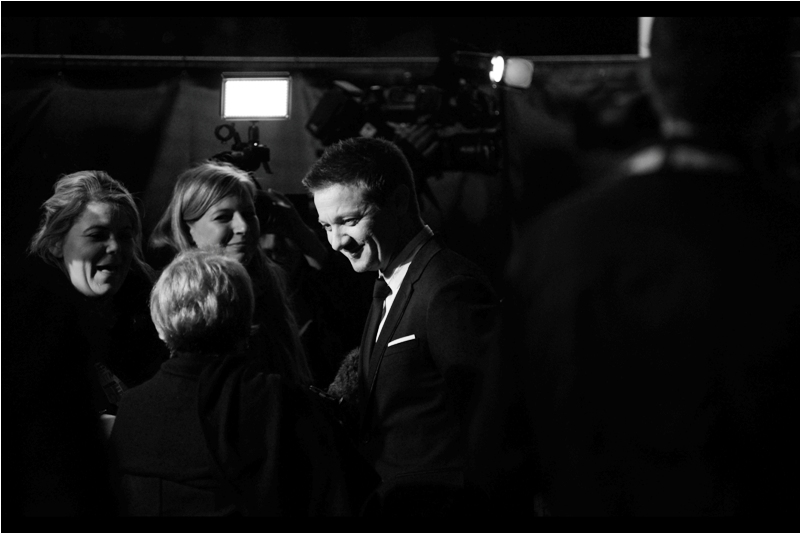 Oh, that's right. Jeremy Renner is also at this premiere. Here's a shot of him while Amy Adams is surrounded by jesters, tricksters, magicians and fortune tellers and gypsies.