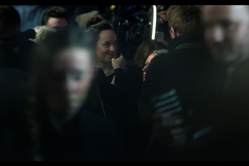 It's not so much people on the red carpet blocking shots of stars that I mind (though I do mind that in this case it's Dakota Johnson) it's when they're doing it becauase they're distracted by their freaking mobile phones. Hey, a55holes : your friends' instagram pictures of dinner will be just as boring if you look at them once you're seated or driving home....