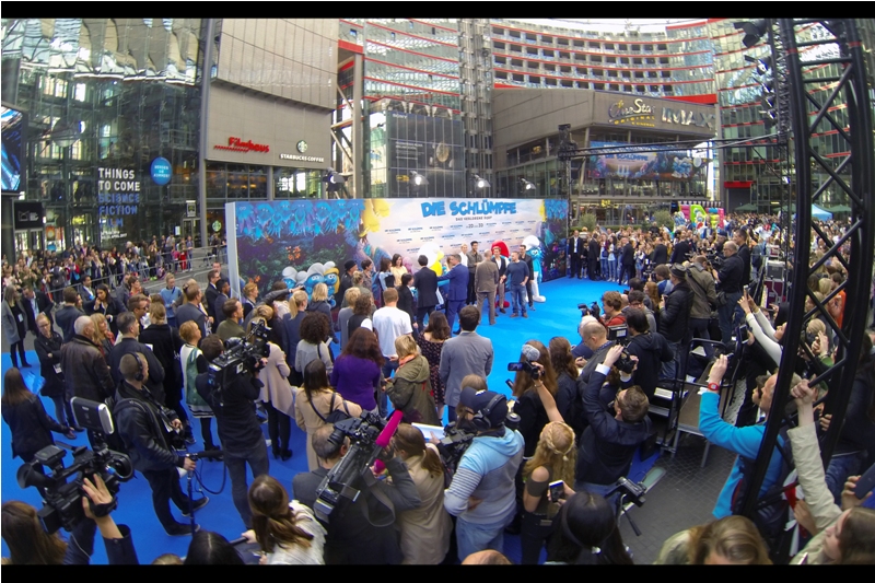 <translated from the German> "Well... we could stay here on the Smurfy blue carpet while our eyes slowly adjust to a world without green and red, or we could head in for free popcorn and drinks?"