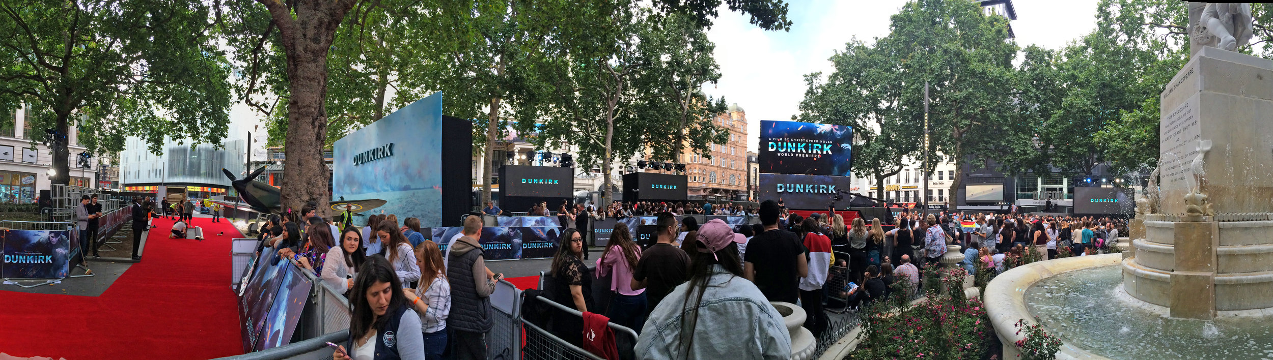 My wristband #286, acquired late yesterday evening, promised a horrific spot in the third or fourth row of a pen, however I found a second-row spot close to the Paparazzi (left) the stage (far distant/right), and a bemused statue of William Shakespeare (far right)