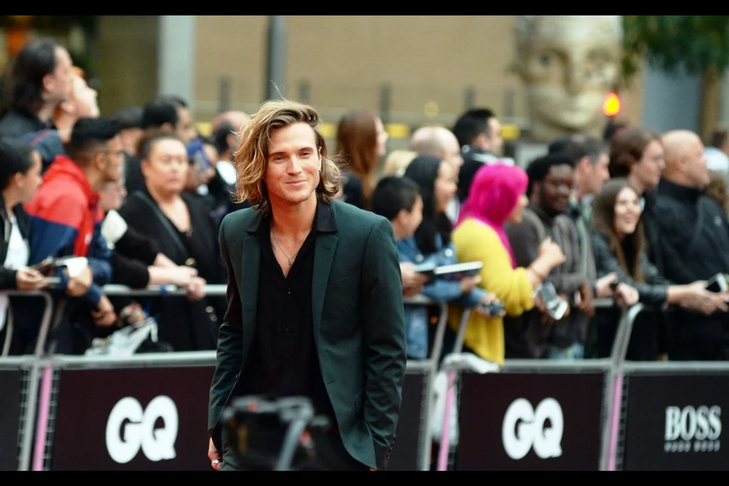 I don't know who this is, but I'm writing "green jacket, v-neck black t-shirt" into my fashion journal. I want to start wearing it in about six or seven years, and try to catch the trend early when it comes around again.
