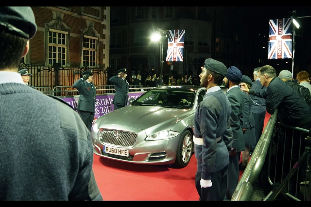 After a suitable last minute sniffer-dog check (during which I had to admit I owned that suspicious looking bag sitting near me, but was not asked to comment on the Pentax over my *other* shoulder), a silver Jaguar rolls up the red carpet. I'd like to say it didn't slow down as it ran over homeless people, but even in the name of questionable humour I shan't.
