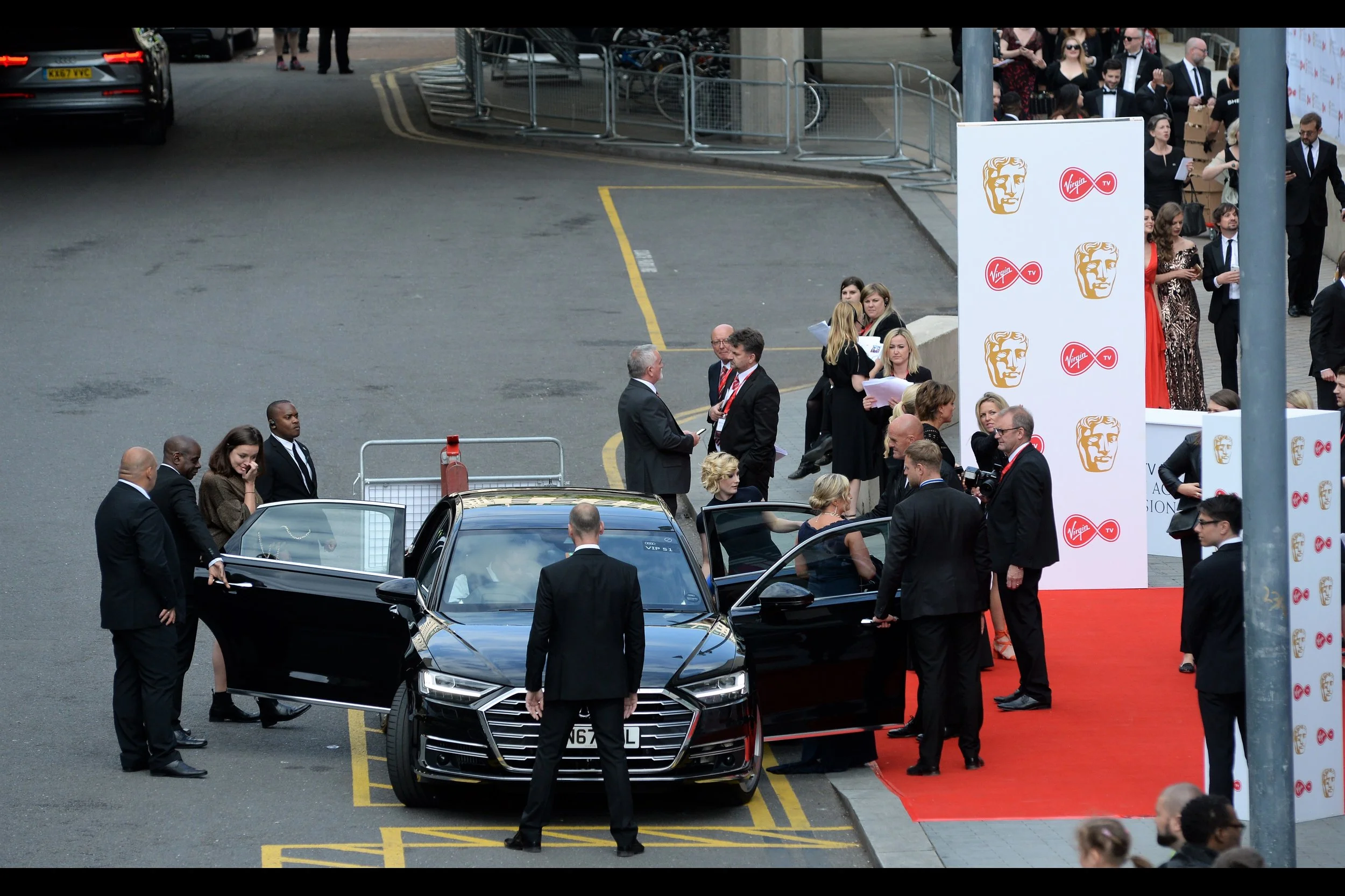 The lady exiting at the back of the car is Jodie Whittaker : the current (upcoming?) incarnation of Doctor Who.