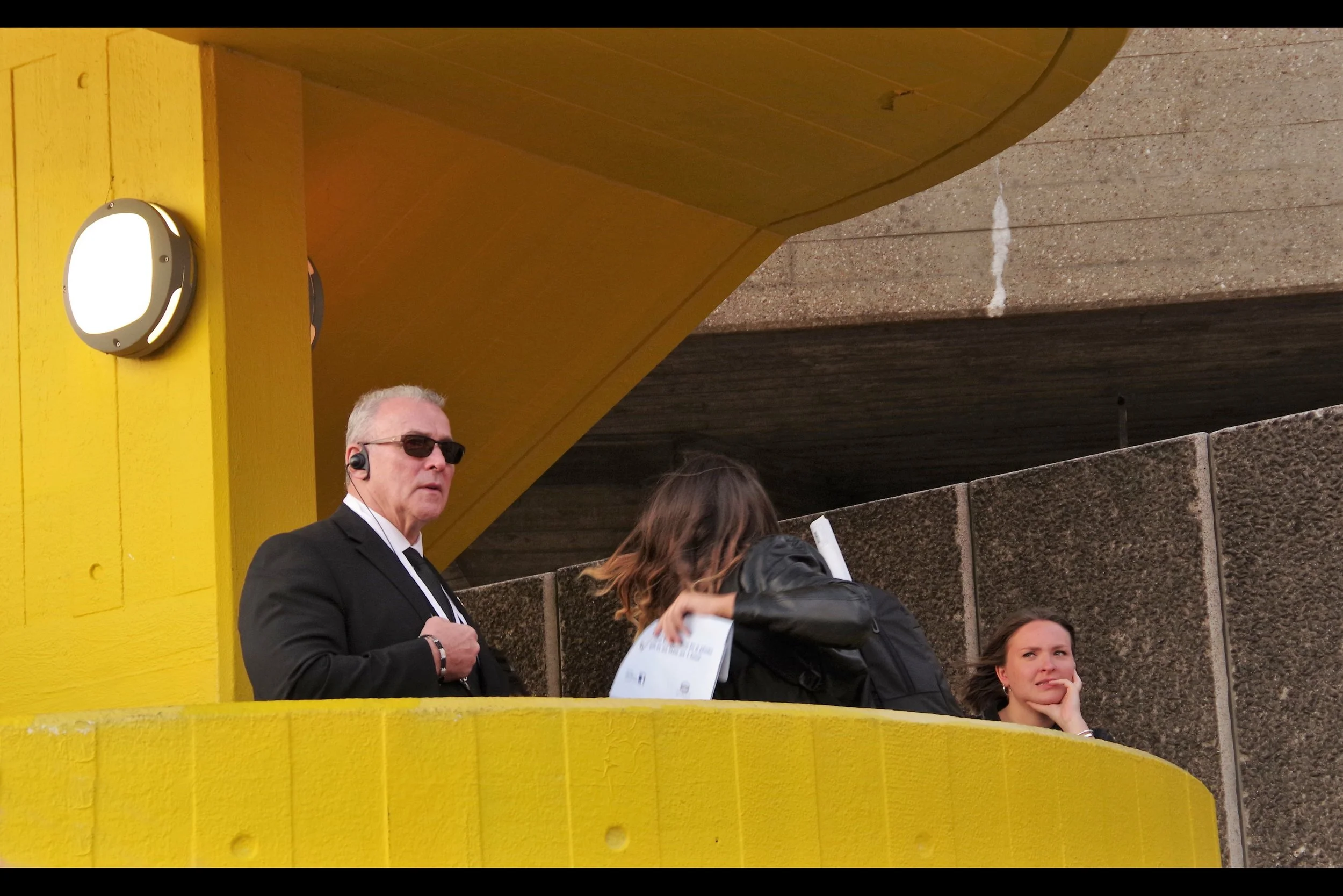 “It’s not about premiere photography. It’s about Respect. And Democracy. And kickass sunglasses”. This man is That Force. And there’s no denying This Man And His Determination That You Will Not Photograph From Where He’s Standing.