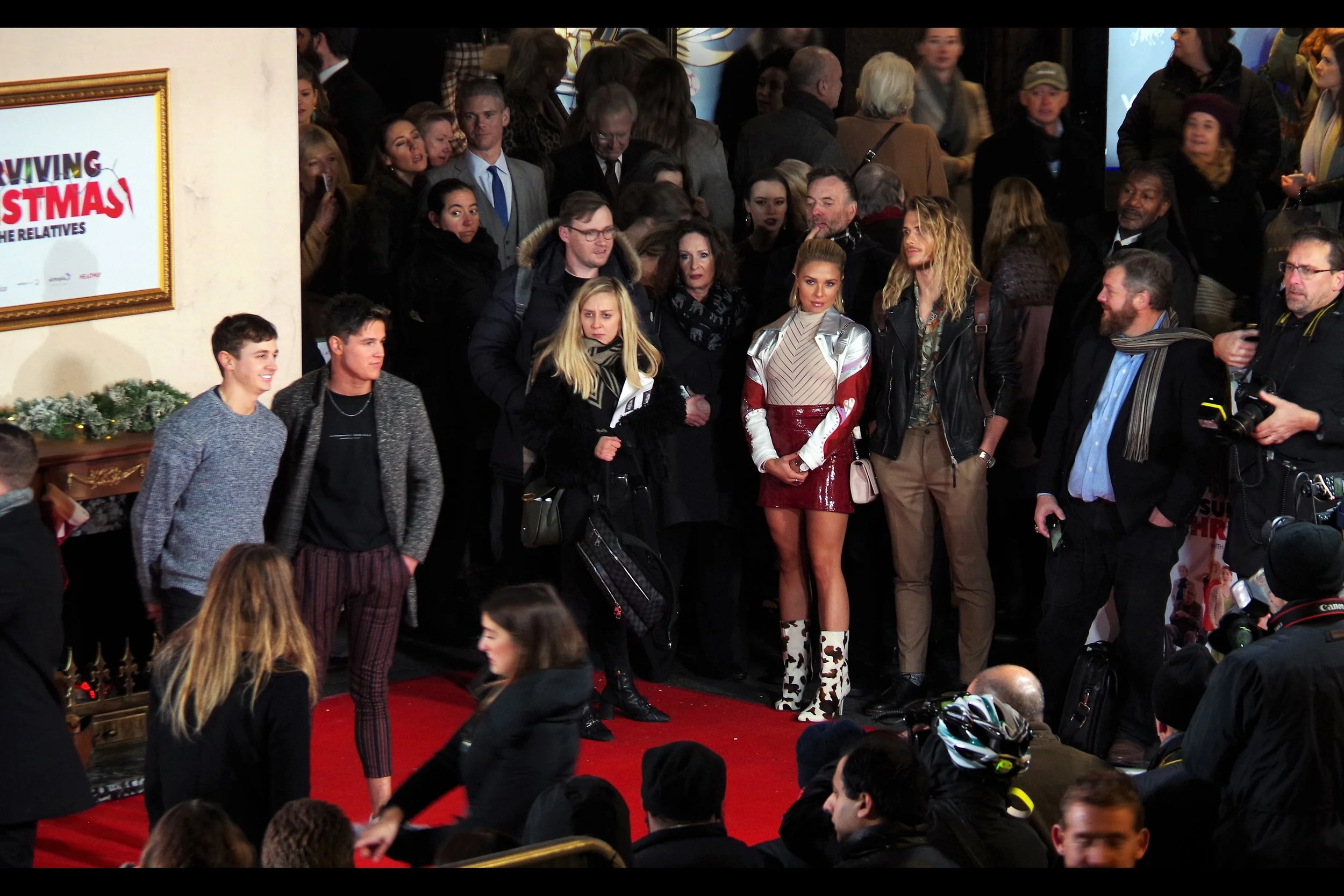 So obviously I’m photographing the two dudes facing the photographers in front of the posing wall, and not the lady in the short maroon skirt, semi-translucent mesh top and cow-patterned boots….