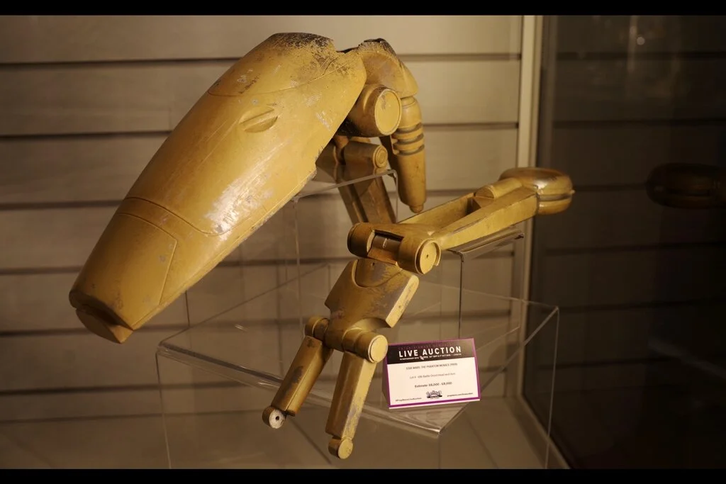 After all this time, I still can’t figure out why, when given an EXPLICIT order to “ Wipe them out, ALL OF THEM ”, these droids surrounded the Gungans and accepted their surrender. (Just in case you think I only think the new Star Wars films are crap.) Battle Droid head and arms from The Phantom Menace: Estimate: £6,000 - 8,000