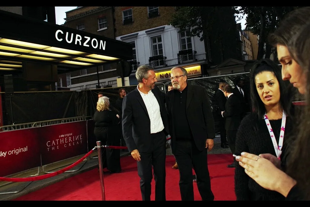 (at far right) ”You’re praying? At a time like this?” ”Yeah… how else is Joaquin Phoenix going to show up to this event?” ”Well… he’s not in this series and he’s not on the list and he’s got an event tonight and it’s not here” ”Hence the praying. Obviously”