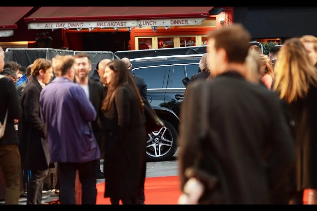 A car has arrived, and for the avoidance of doubt, every person on the carpet right now APPARENTLY MUST BE THERE - none of them are guests, none of them are stars, and none of them are ticket holders… they are just security, attendants, PAs, and organisers. Are this many required, or are they literally put there to block views and (say) make sure that only official photographers are able to take photos? Only your sense of paranoia can say for sure.