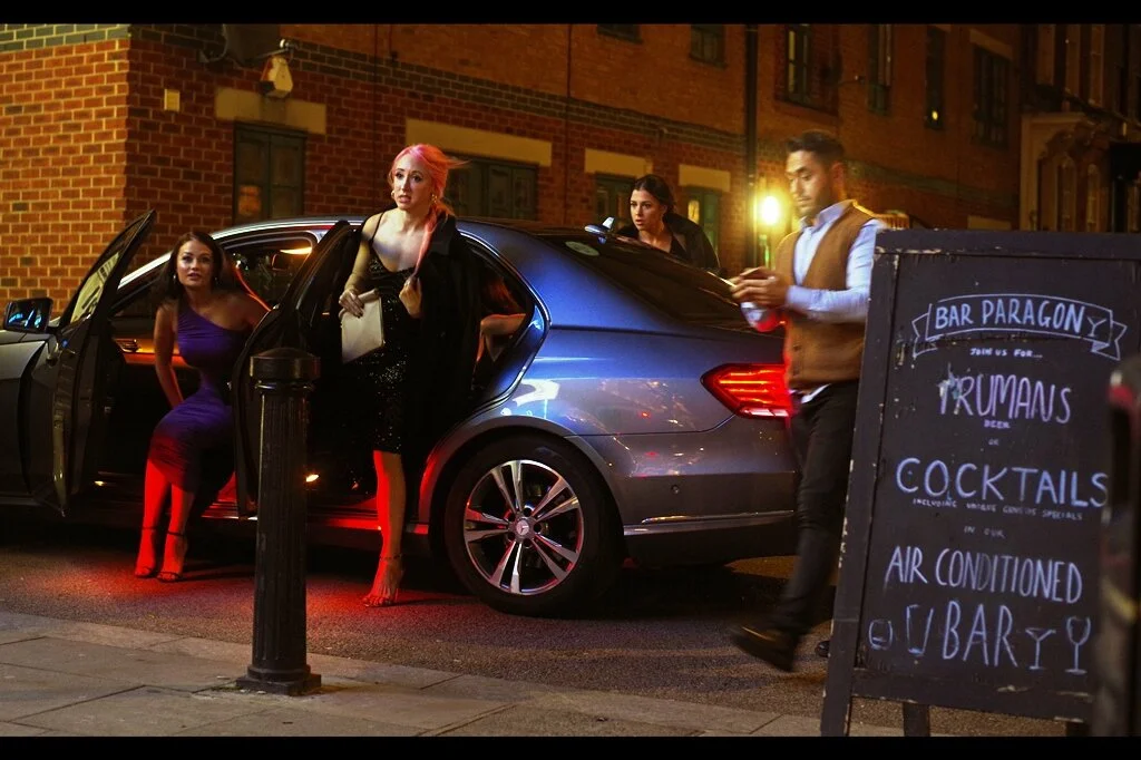 A car pulls up and a lady in bright pink hair and a low-cut top gets out of the back. I naturally take a photo, and am glad that I did….. because the lady in the blue dress getting out of the FRONT PASSENGER side seat is the one who is actually in the movie.