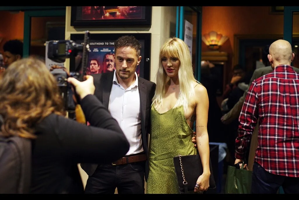 “The only reason I’m posing for this photo is so that later tonight, when we have an argument, I’m going to win it because I was right and there WAS a dude wearing a checked shirt to this event. Please keep him in frame.”