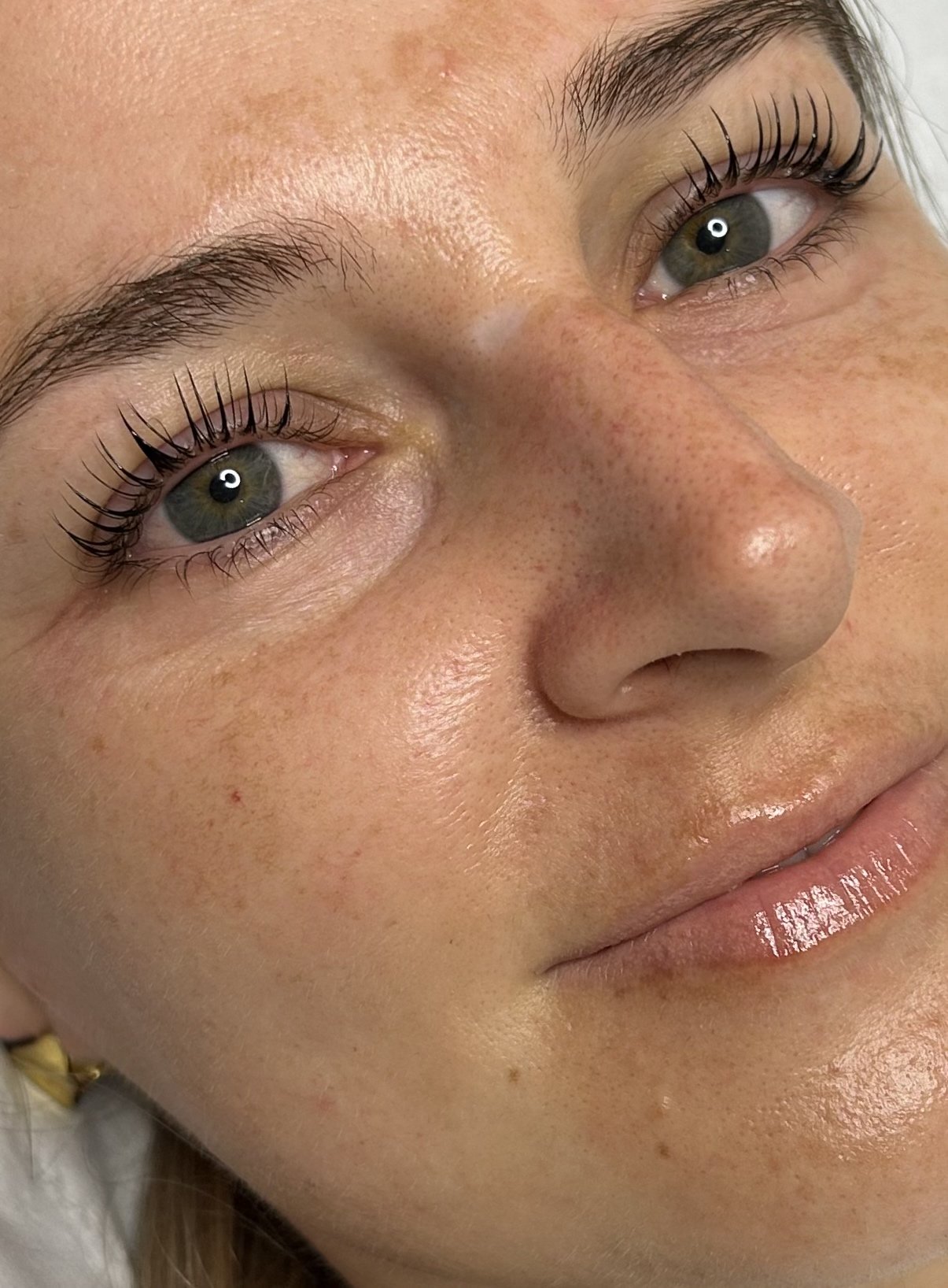 Close-up of a woman's face showing the result of KOREAN lash lift treatment.