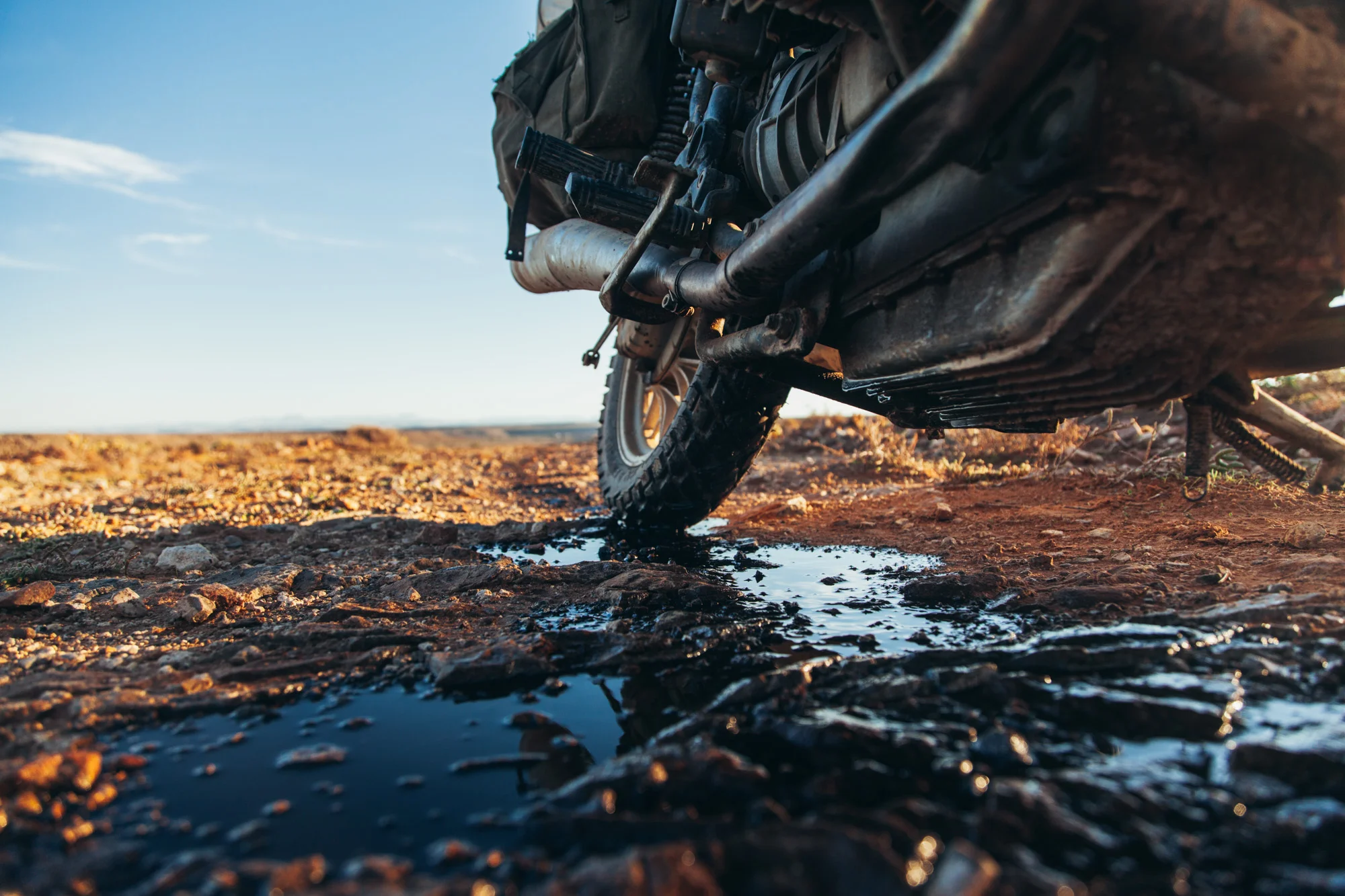 A rouge rock cracks the sump of my bike, emptying all 2 litres of oil onto the dirt. The risk of riding without a sump guard ends the motorcycling journey here