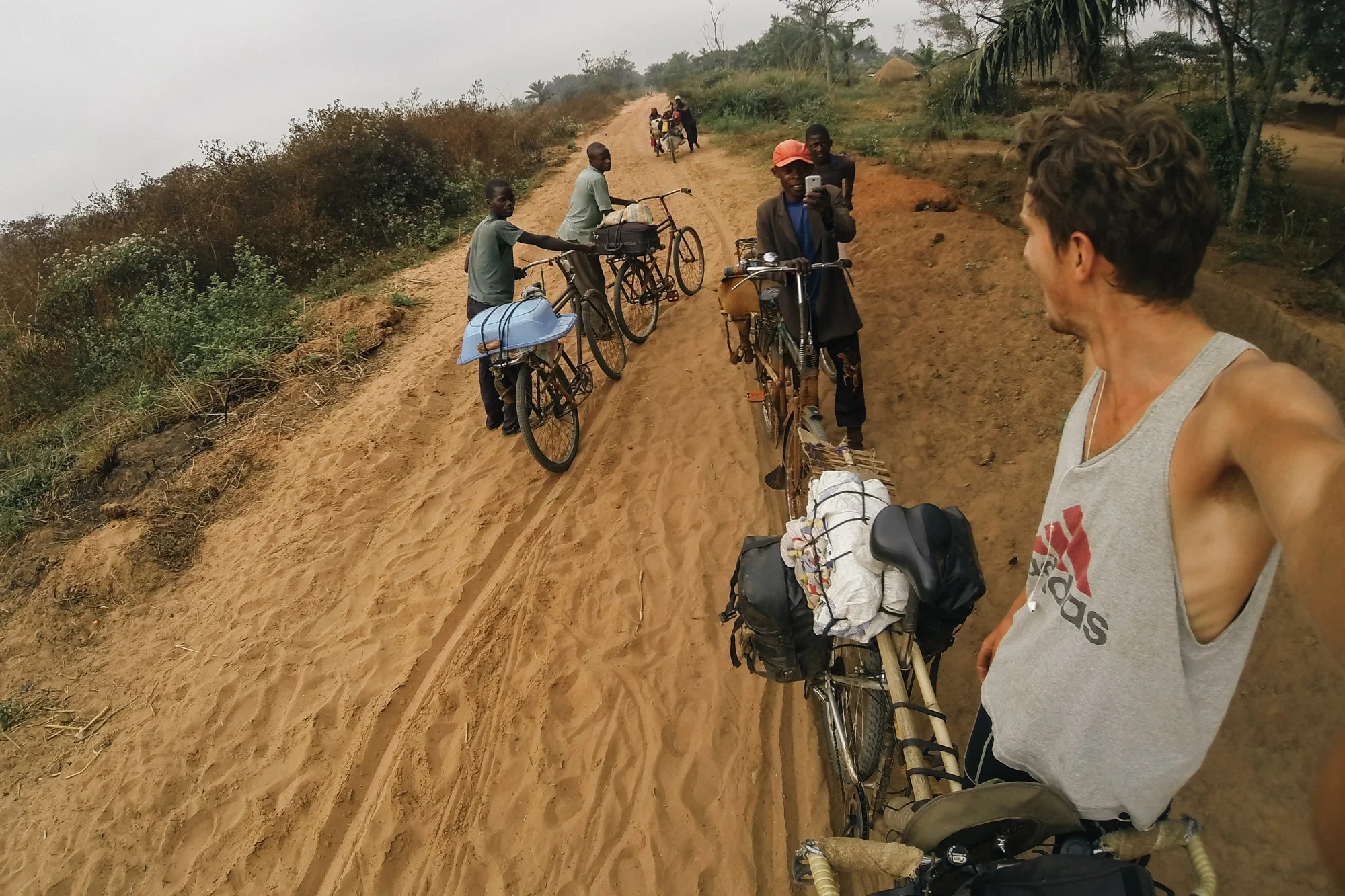 A local cyclist takes a photo of me on his phone. The road here is near impossible to cycle so everyone is left to push along the well trodden single file lane.