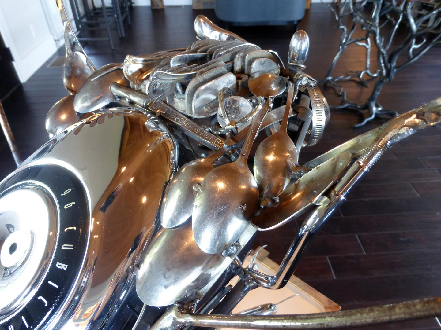 Detail of the Owls head and back show Harley parts, a crystal globe, gun grip, antique lawnmower engine, antique spoon provided by her Grandmother.
