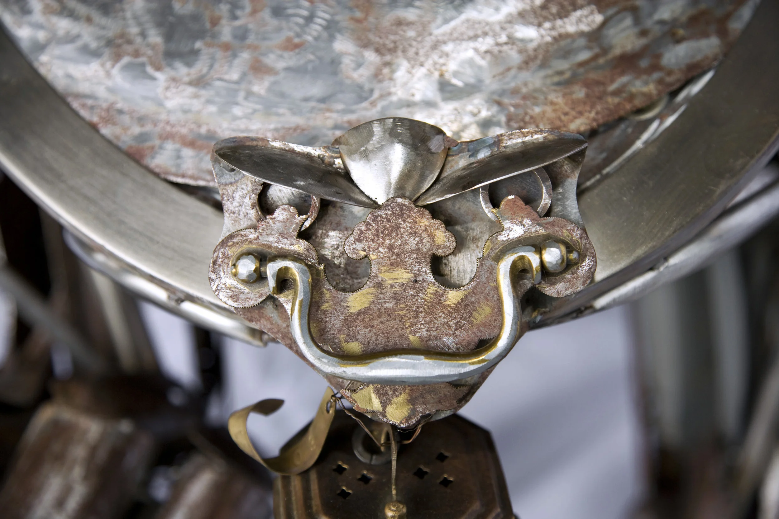 Gremlin face on her collar made of spoons and dresser hardware.