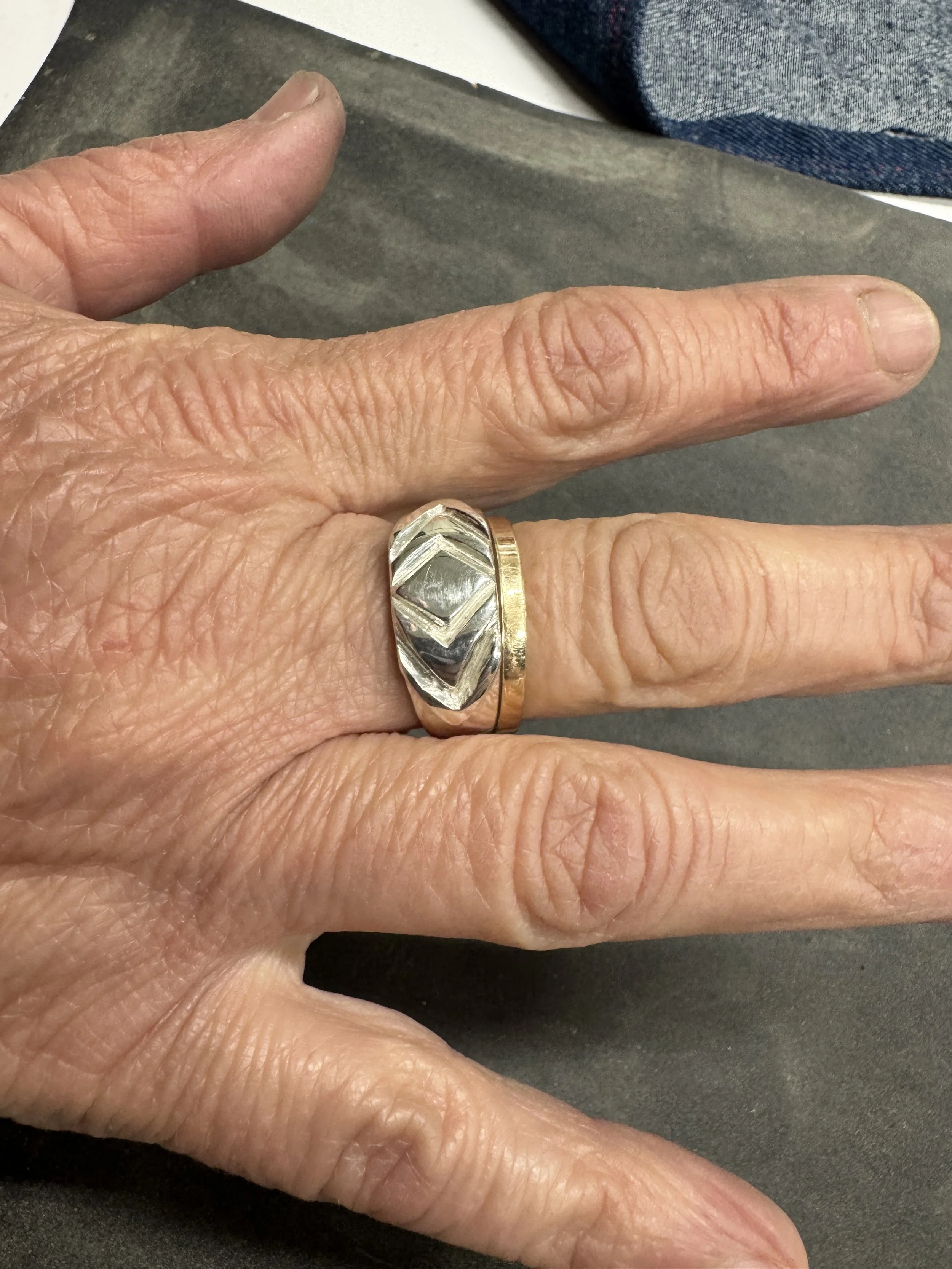 wide silver diamond geometric pattern ring on hand