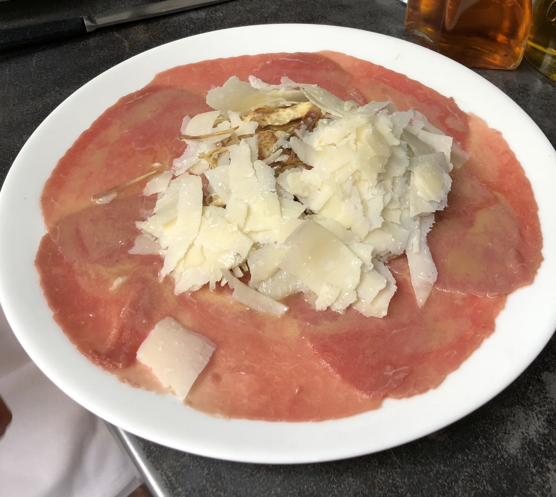 Beef carpaccio with shaved raw artichokes, parmesan cheese and lemon