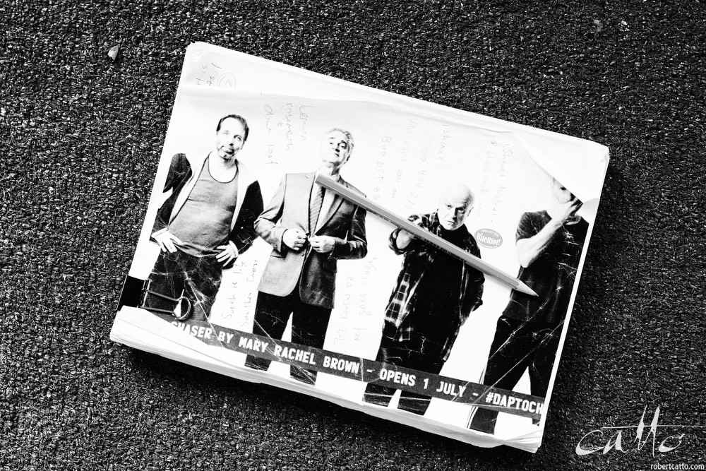 Danny Adcock, Noel Hodda, Jamie Oxenbould & Richard Sydenham rehearse with director Glynn Nicholas for Apocalypse Theatre's production of The Dapto Chaser, by Mary Rachel Brown, on Tuesday, 23 June, 2015. The show takes place at Griffin Theatre from 1 - 15 July, 2015. Photo by Robert Catto / robertcatto.com.
For the Sinclair family, the cut-throat world of greyhound racing is a religion. And their beloved dog Boy Named Sue is more than a greyhound; he’s their heart and soul on four legs. With the crucial Winnebago Classic on the horizon, Cess Sinclair has one shot at reversing his family’s fortunes for good. Against all the odds, he’s betting on a miracle.
The Dapto Chaser is warts-and-all Australian comedy that gets its hands dirty with the adrenaline, sweat and guts of the dog racing sub-culture. The Sinclairs are a family trapped in the pressure cooker of gambling addiction and when things don’t go to plan, they are forced to gamble the most important commodity of all – their relationship to each other.
Playwright Mary Rachel Brown wrote The Dapto Chaser perched in the bleachers track-side, while director Glynn Nicholas will be going on an all-schnitzel diet to get it over the line.