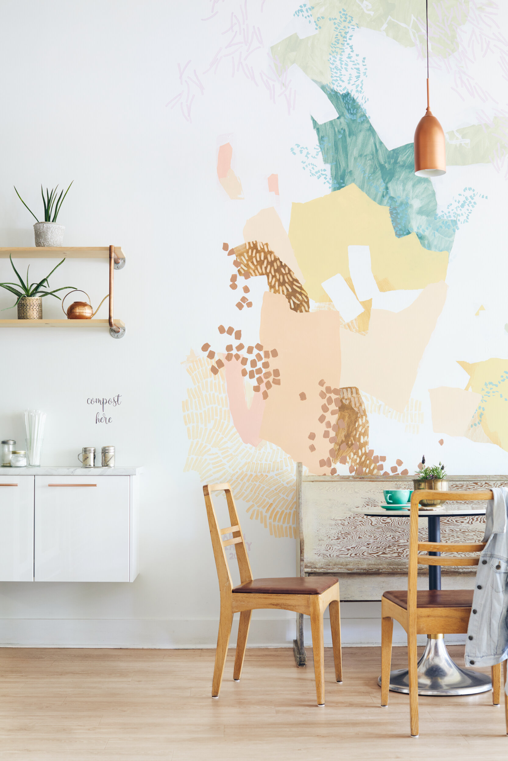  View of cafe table and chairs in Cold Front Gelato in Naniamo, British Columbia, Canada. Interior design by Alana Dick of Ivory Design Company; Mural by Canadian artist Sarah Delaney 