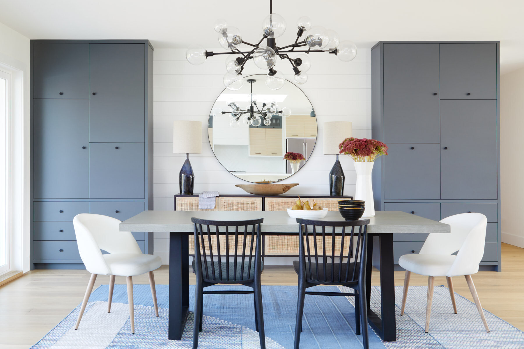  Dining Room at Bird Sanctuary House designed by Alana Dick of Ivory Design Company. Built by Böehm Construction. Four Hands: Chandelier, Buffet, Dining Table. Article: Wood Dining Chairs. Style In Form: White Dining Chairs. West Elm: Rug. Lemontree 