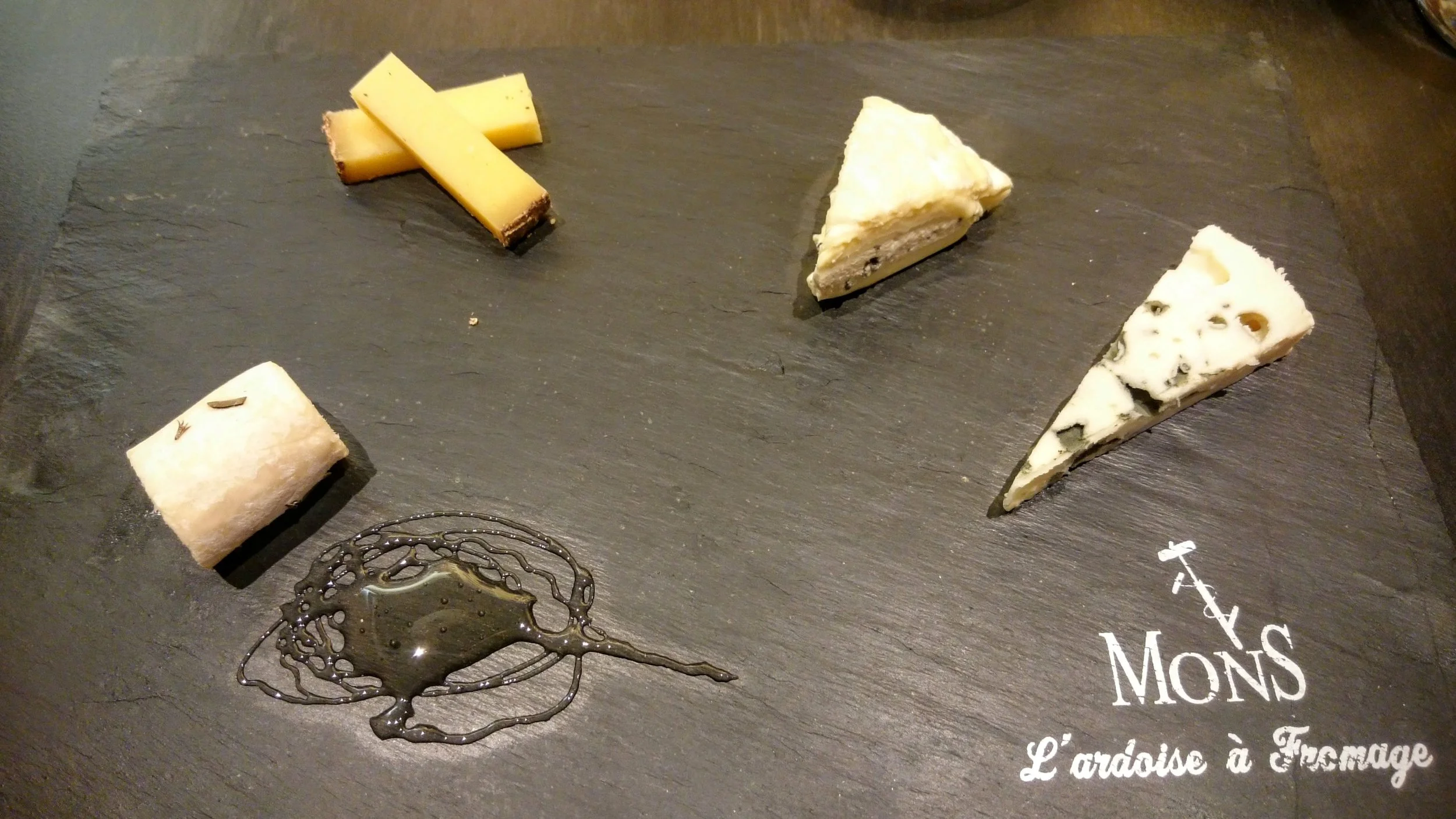 From right to left: a young chèvre with truffled honey, a 24-month comté, Saint-Marcellin with a truffle cream, and Roquefort.
