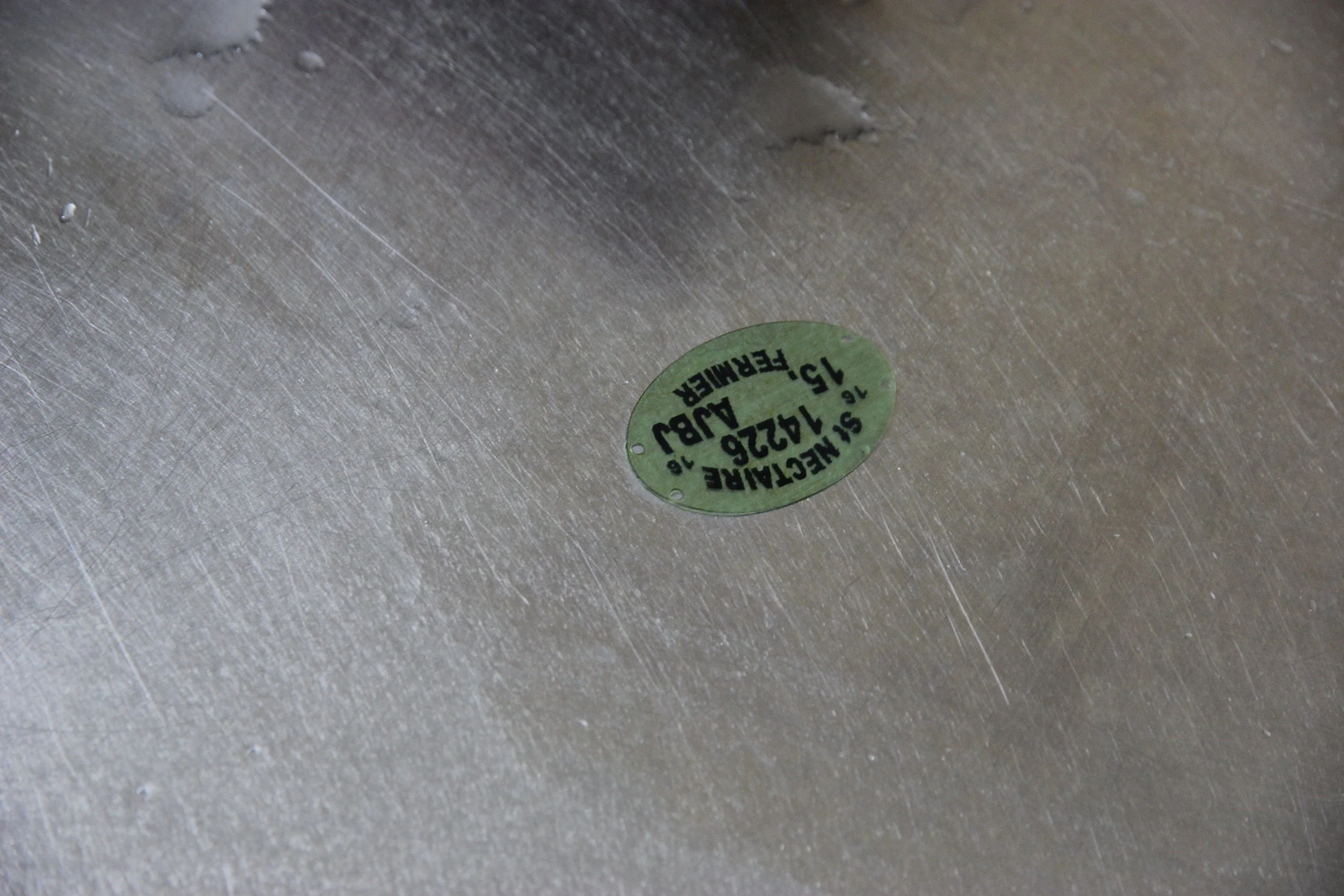The green oval sticker is made of casein, the key protein in milk that converts to cheese, and it put on each cheese. The shape in this case is important: oval indicates raw milk. If it were pasteurized, the ticket would be square. The farm has a limited number of tickets as St Nectaire production is restricted, and these are the only accepted indicators of AOP status. 