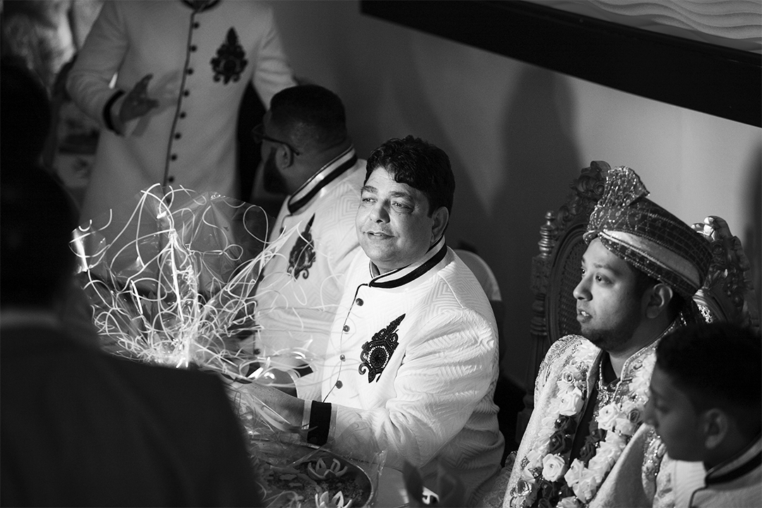 The Banquet The groom is seated with family at a long table with his family and gets ready to eat.