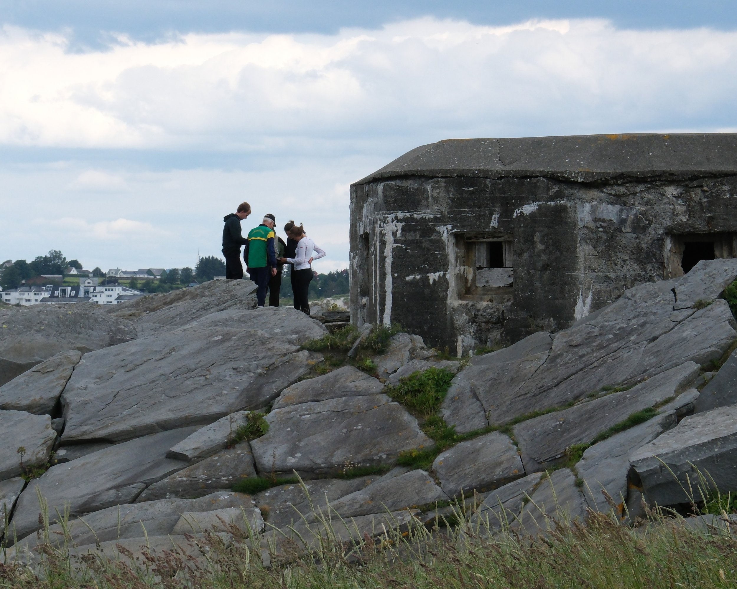 Deltakere på teambuilding utforsker terrenget ved en historisk bunker på Solastranden.