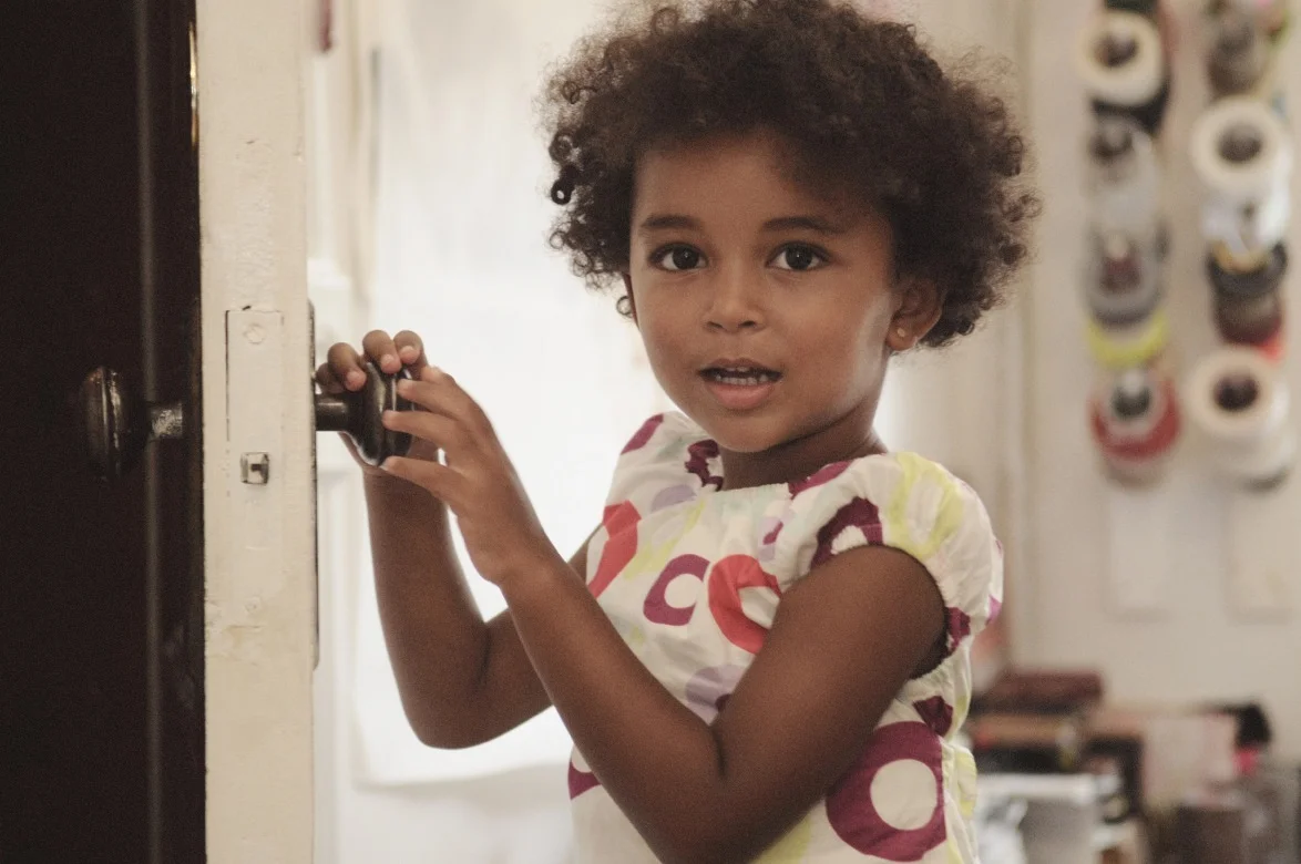 It doesn’t seem like the right setting for a princess or her finery. But it’s here that 3-year-old Neema Lazzaroni decides to create a pile of the tulle, tutus, lace, and sequins that makes up her enviable princess dress collection. “This one is my favorite,” Neema, the artist’s daughter with her husband Mario , declares. She proudly holds up a lime green dress before switching to a bright off-the-shoulder yellow dress with ruched tulle along the skirt. “I mean this one.”