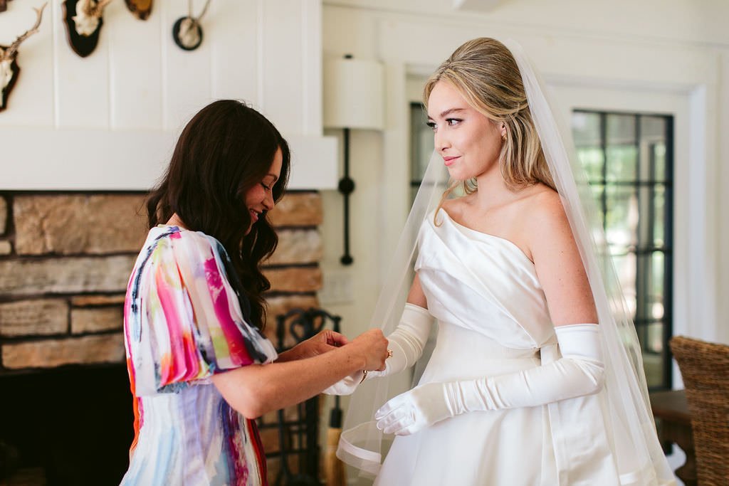 bride getting ready with bridesmaid