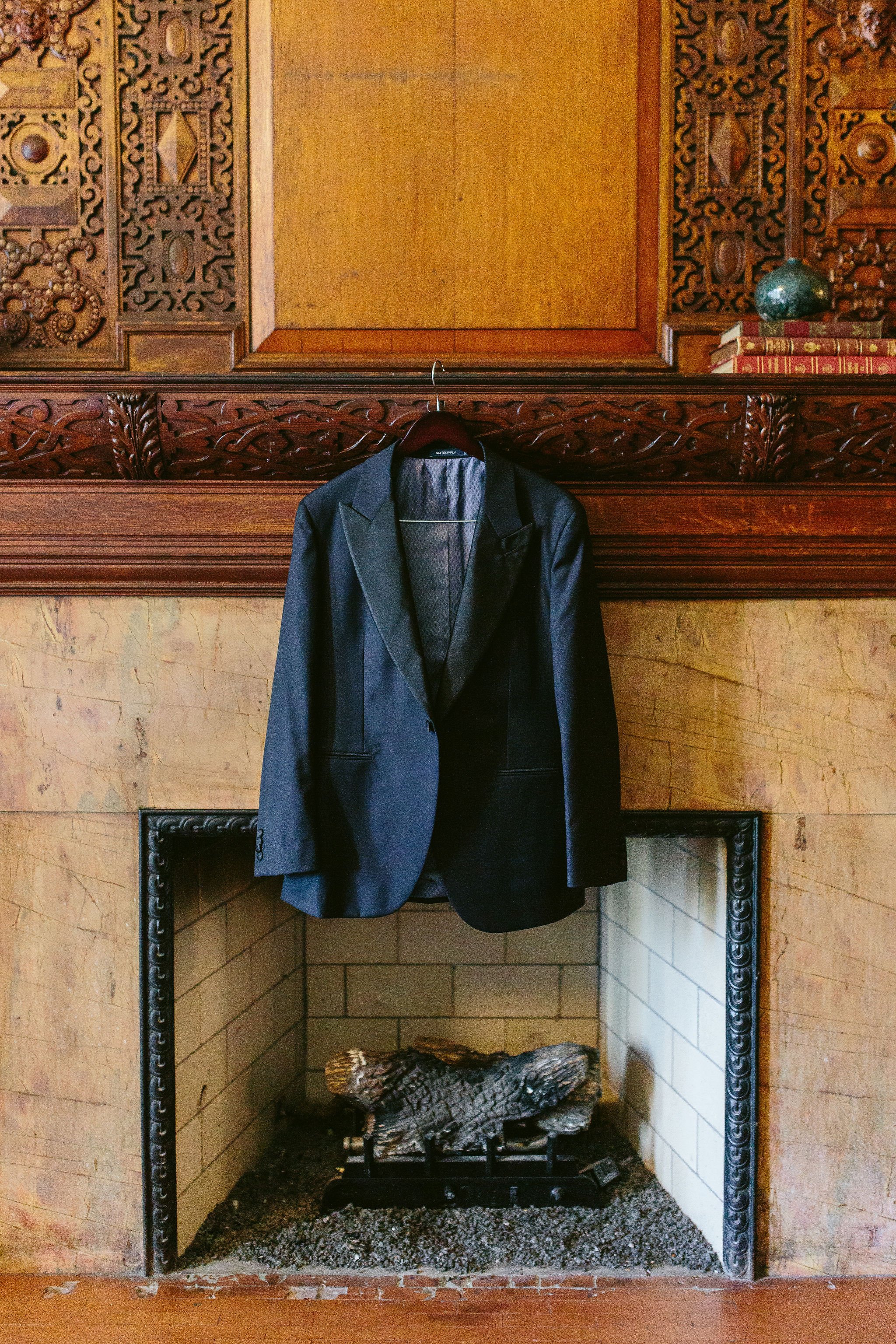 wedding tux hanging on fireplace