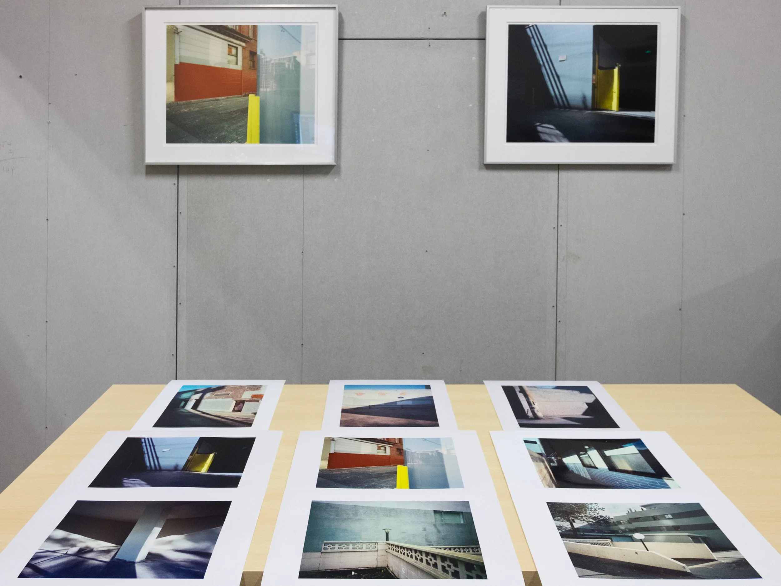 Claire Chao 在工作室內平鋪檢視藝術微噴的紙張試印，並比對掛上牆面的裝框效果。