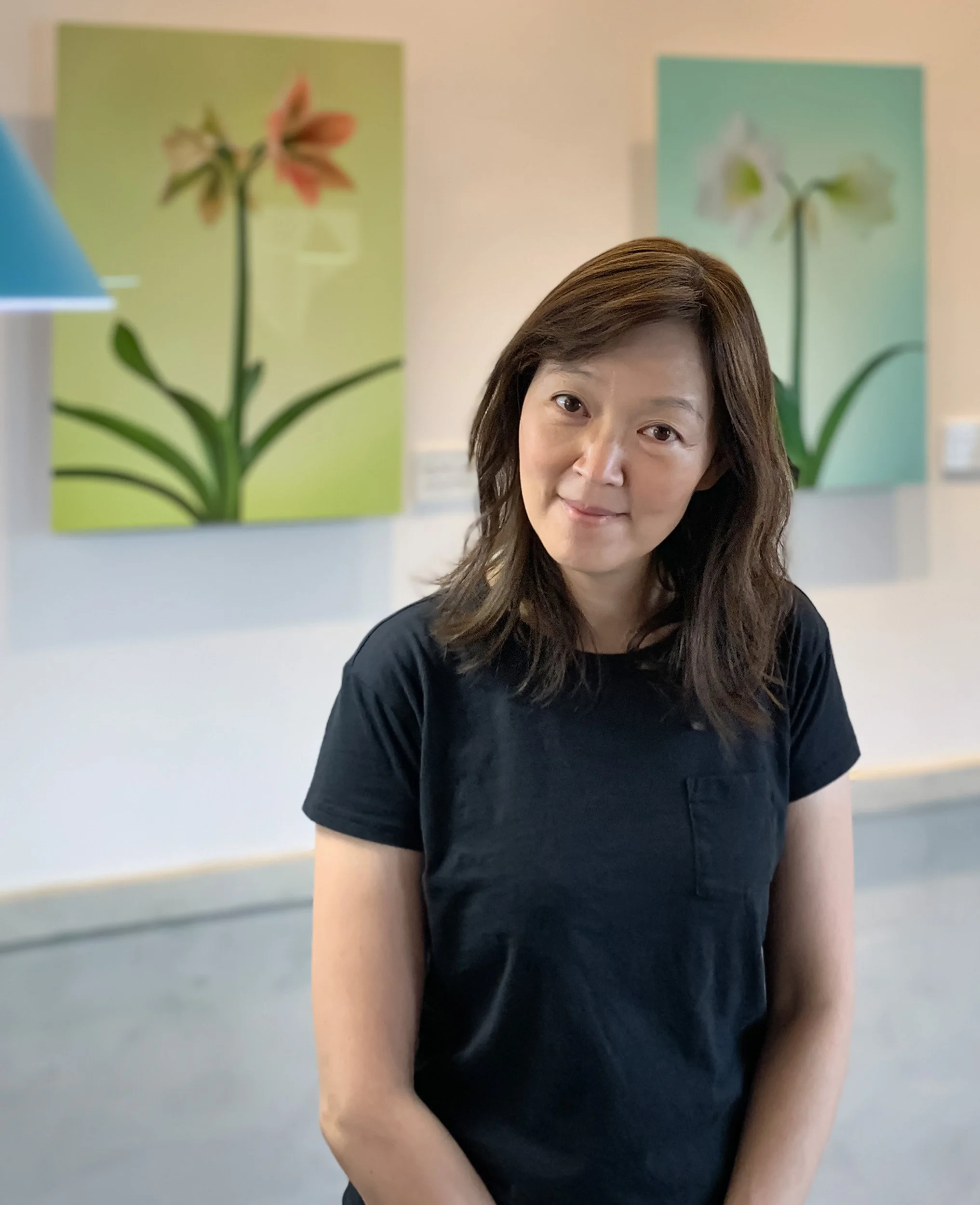 Claire Chao, Fine Art Photographer and Founder of Metal Print Studio, standing with her floral metal prints. 趙湘瑋，藝術攝影師與瑋思影像創辦人，與其花卉金屬影像作品合影。