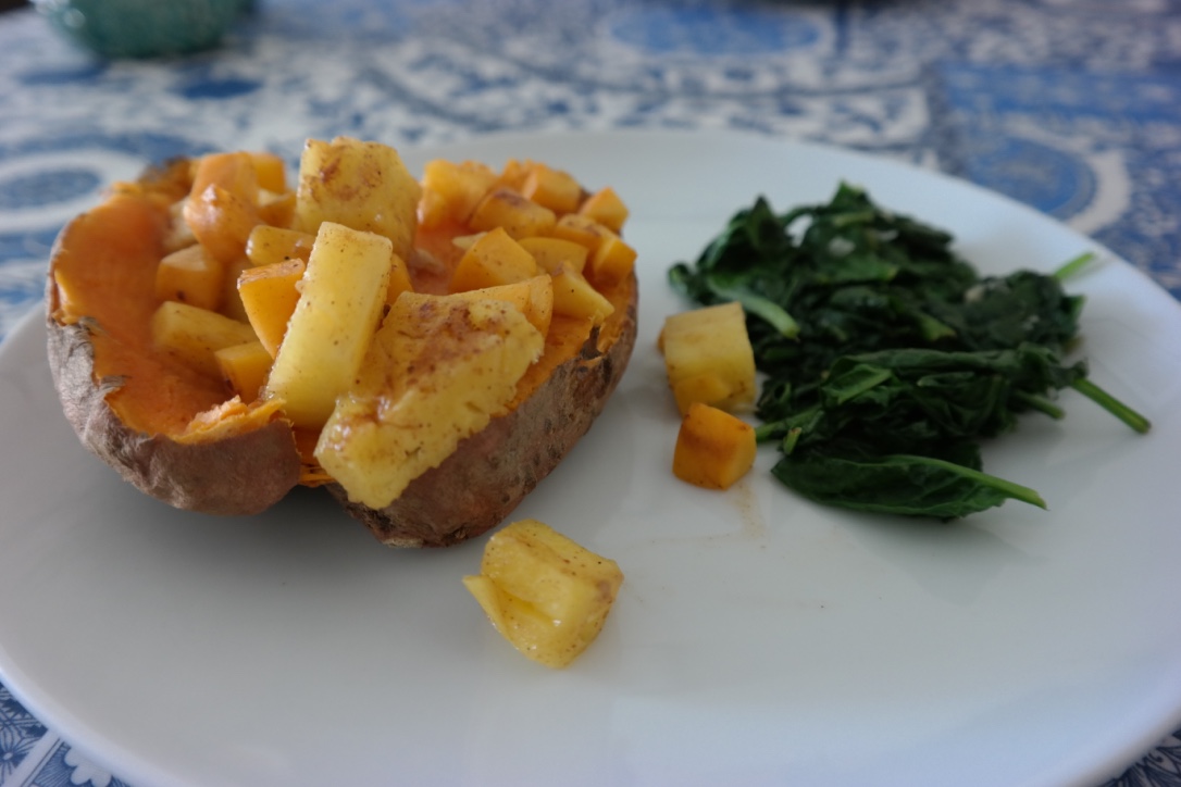 Baked sweet potato, topped with pineapple and apricot chunks . I put the fruit in a saucepan with some coconut oil, nutmeg, and cinnamon while the potatoes were cooking, and softened them. I sauteed some spinach on the side, and this was a very easy, super delicious meal.
