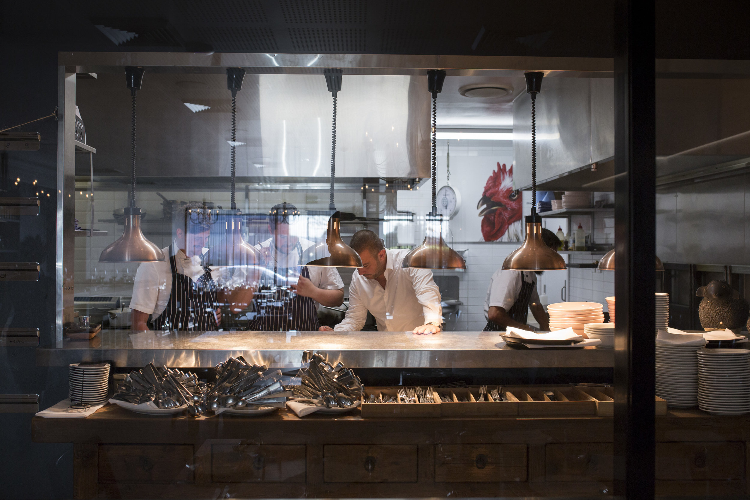 Helenika Restaurant, Nobby Beach, Gold Coast. Owner Simon Gloftis talking with Chefs in the kitchen
