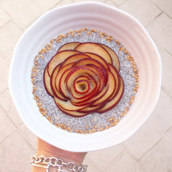 Plum flower on a bed of chia pudding surrounded by flax seeds.