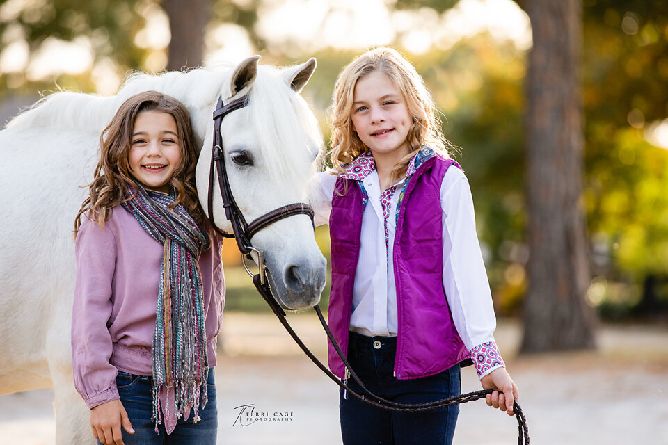 Young riders and sisters with pony