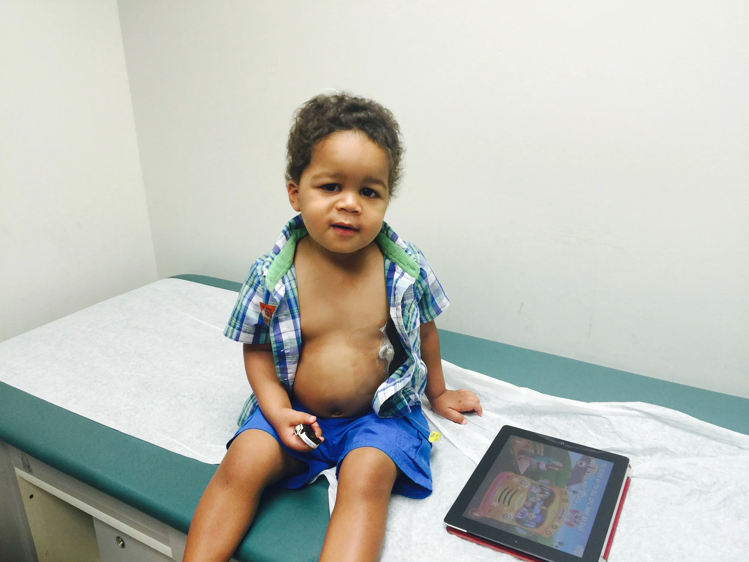 Day 389: Elliott plays a game on an ipad while receiving chemotherapy.
