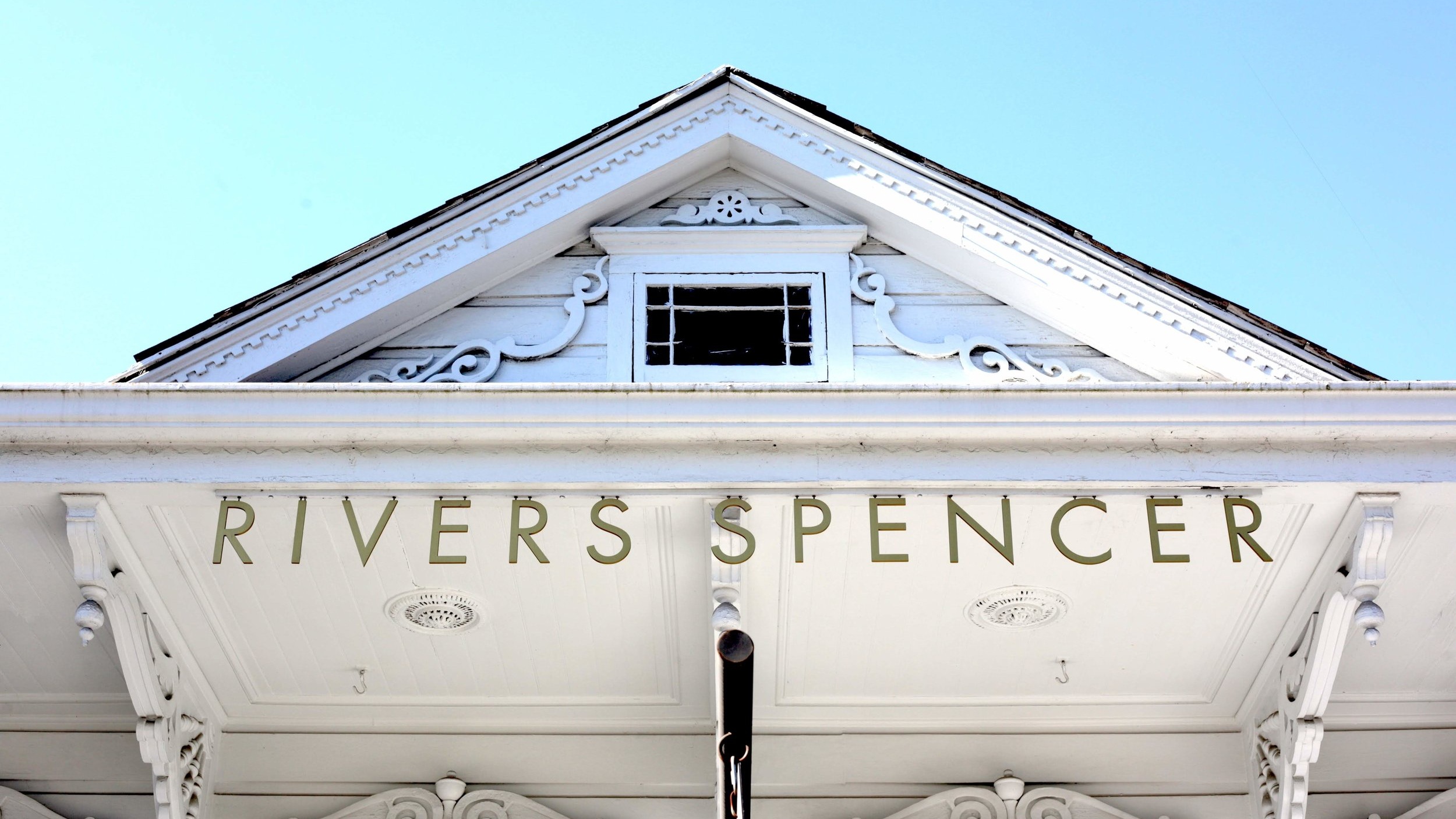 Hanging metal cutout letters that spell out RIVERS SPENCER