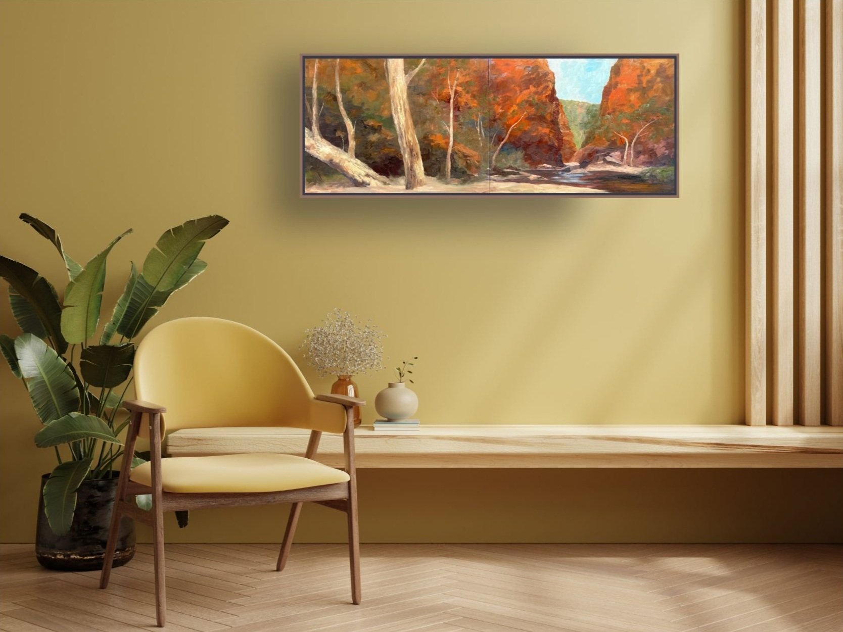 Sitting area in stylish home, painted yellow ochre, with desert gorge plein air painting on wall