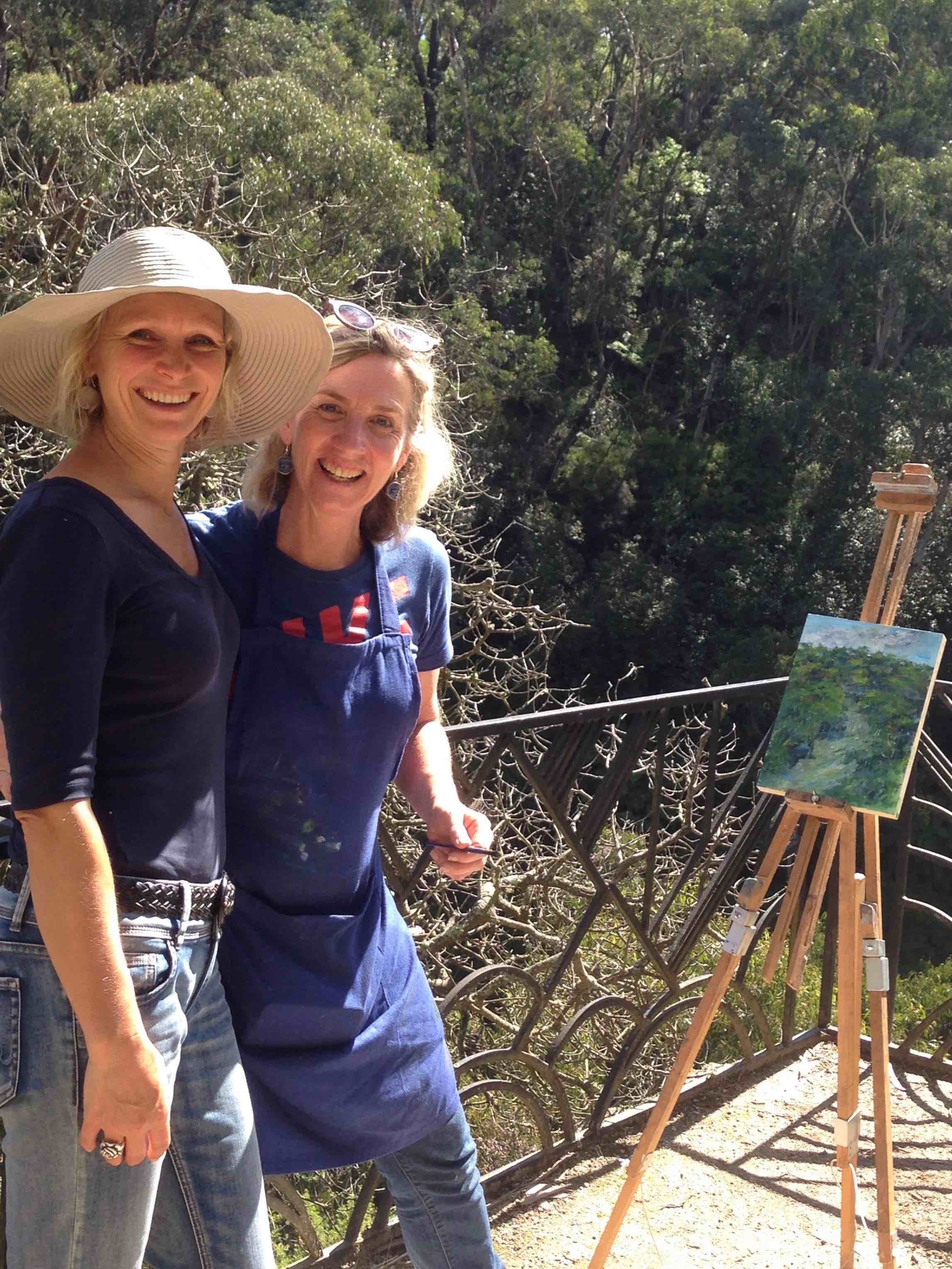 Blue Mountains artist and workshop student smiling while standing above bushland with an easel in background