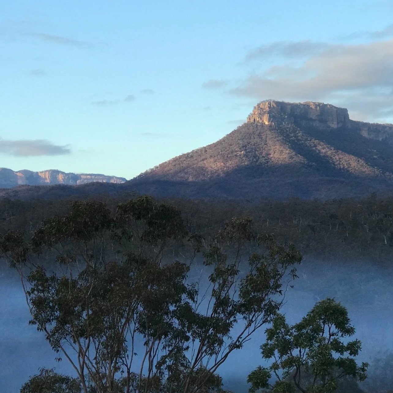 Mist in the valley below a mountain outcrop in the Capertee Valley