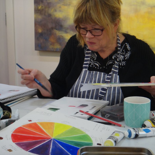 Artist painting in an art workshop with colour wheel
