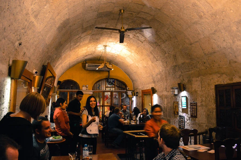 Inside the zig zag restaurant in Arequipa Peru. People are eating in the restaurant. The restaurant has a curved ceiling.