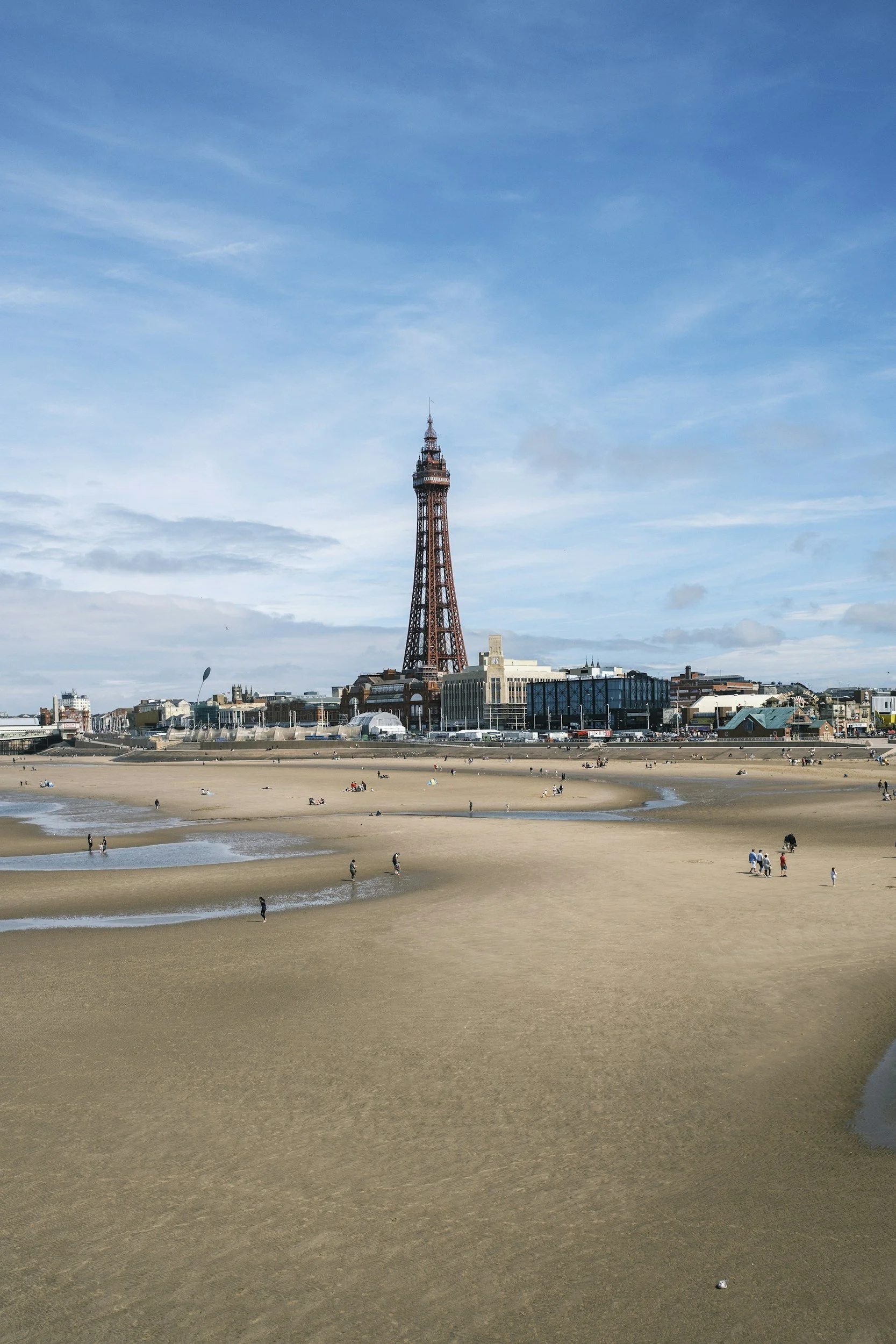 The Blackpool tower from the beach and promenade on a clear day.