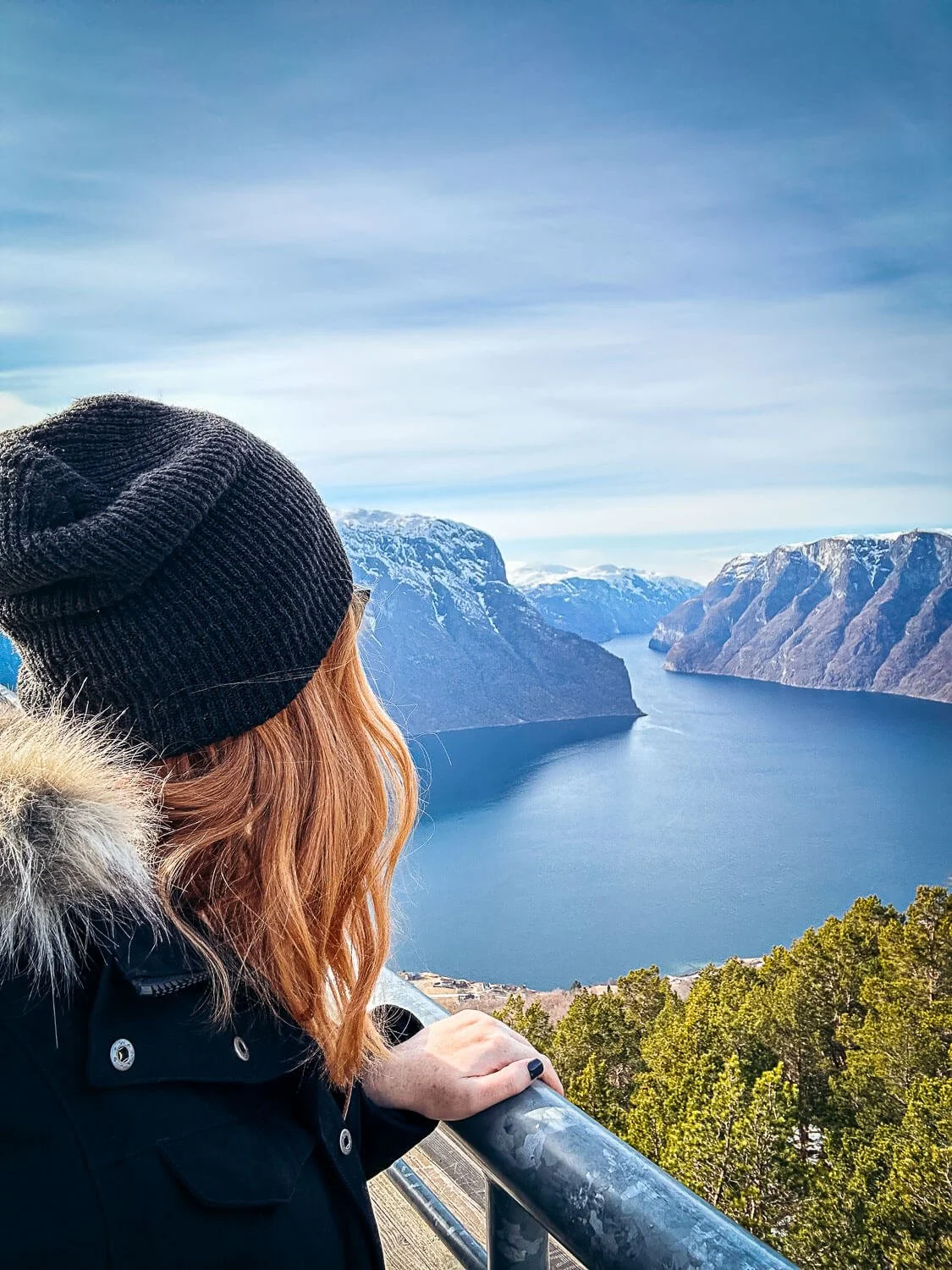 Red haired traveler looking out over the Aurlandsfjord from Stegastein Norway
