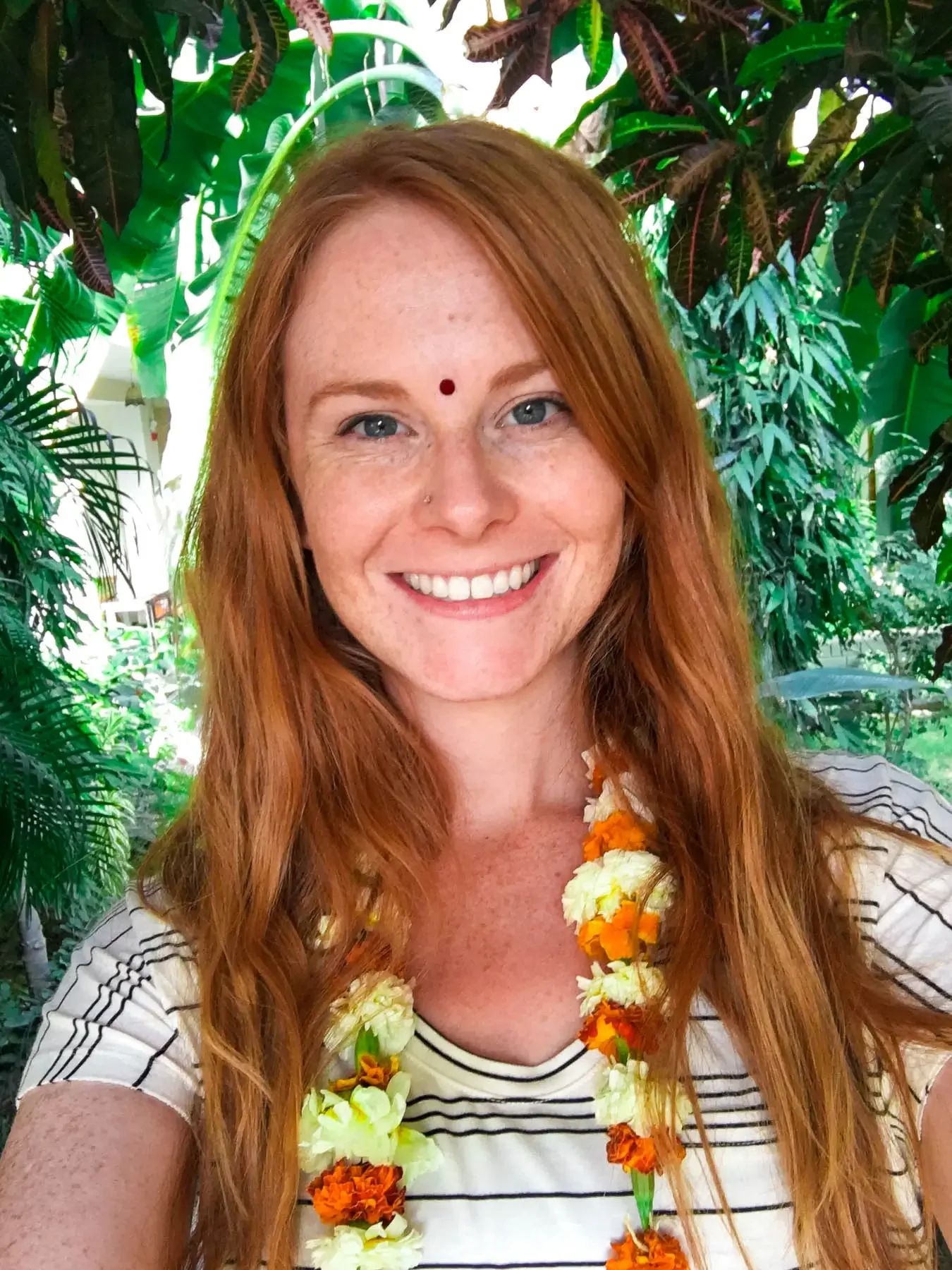 red headed girl wearing a bindi and flwoers